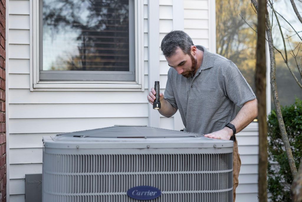 HVAC technician servicing air conditioning system in Oakville Ontario